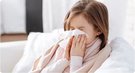 girl with flu blowing nose